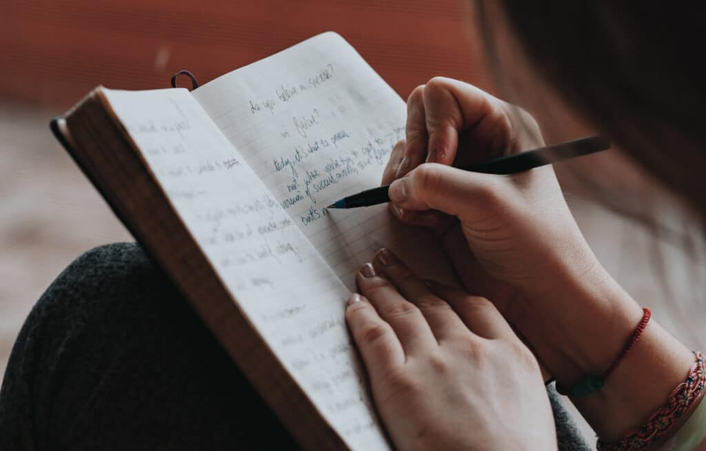 teenage girl journaling out her specific goals